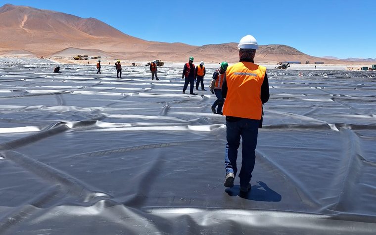 Superficie impermeabilizada en operación de salar, con equipos en el fondo